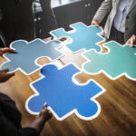 Team Work symbolisiert durch große Puzzlestücke